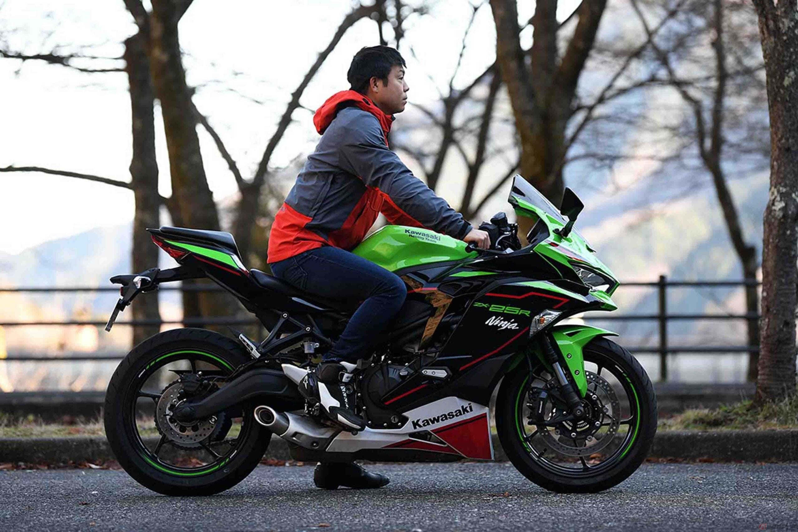 カワサキ「Ninja ZX-25R」と筆者(レーシングライダー・大久保光)。レーサー気分を味わえるポジションに設定されています