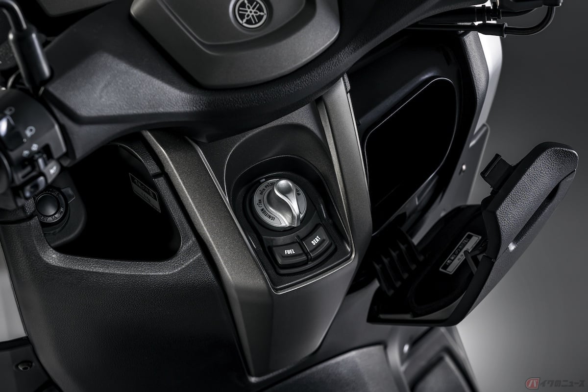 ヤマハ「NMAX ABS」は、フロント左側にシガータイプの12V電源ソケットを備えた600mLのペットボトルを収納できるインナーボックス、右側には形状の異なるフタ付きの小物入れを装備