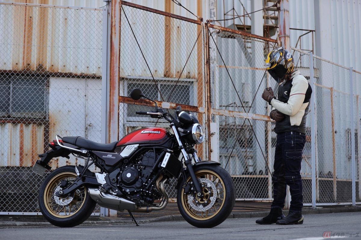 初代“Z1”譲りのファイアーボールカラーの「Z650 50th Anniversary」と試乗前の筆者(青木タカオ)