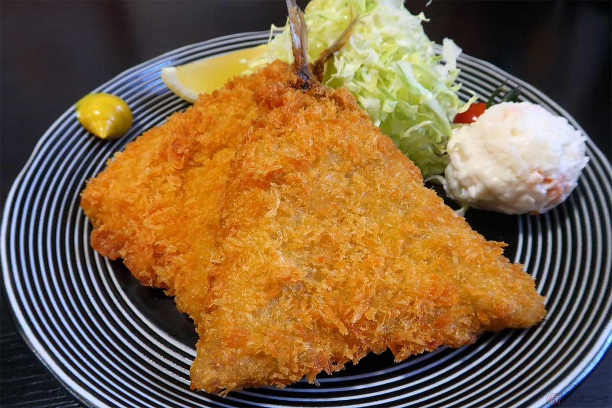 綺麗に三角に揚げられたアジフライの普通サイズが2枚。揚げたてサクサクで美味。定食にはご飯、みそ汁、小鉢、漬物が付く