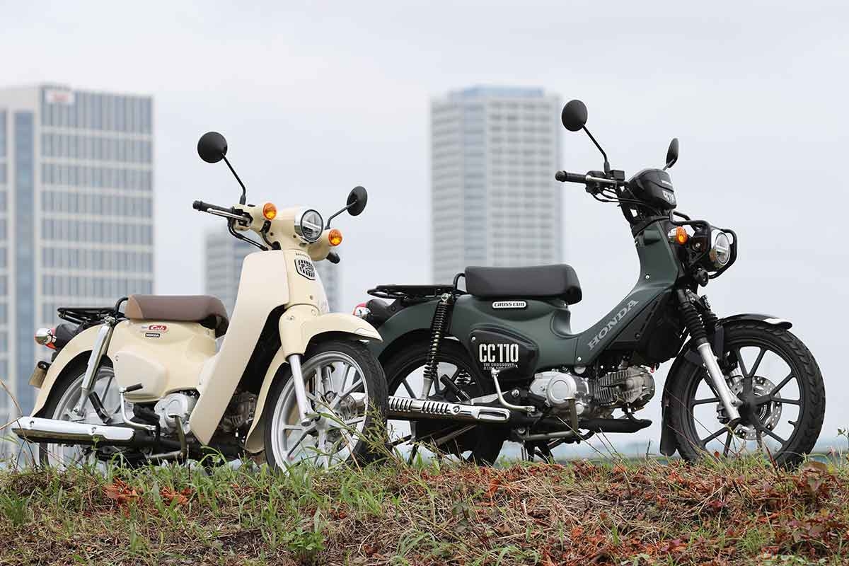 ホンダの原付2種ビジネスバイク「スーパーカブ110」(左)をベースに、アウトドアテイストのクロスーバースタイルに仕上げられた「クロスカブ110」(右)