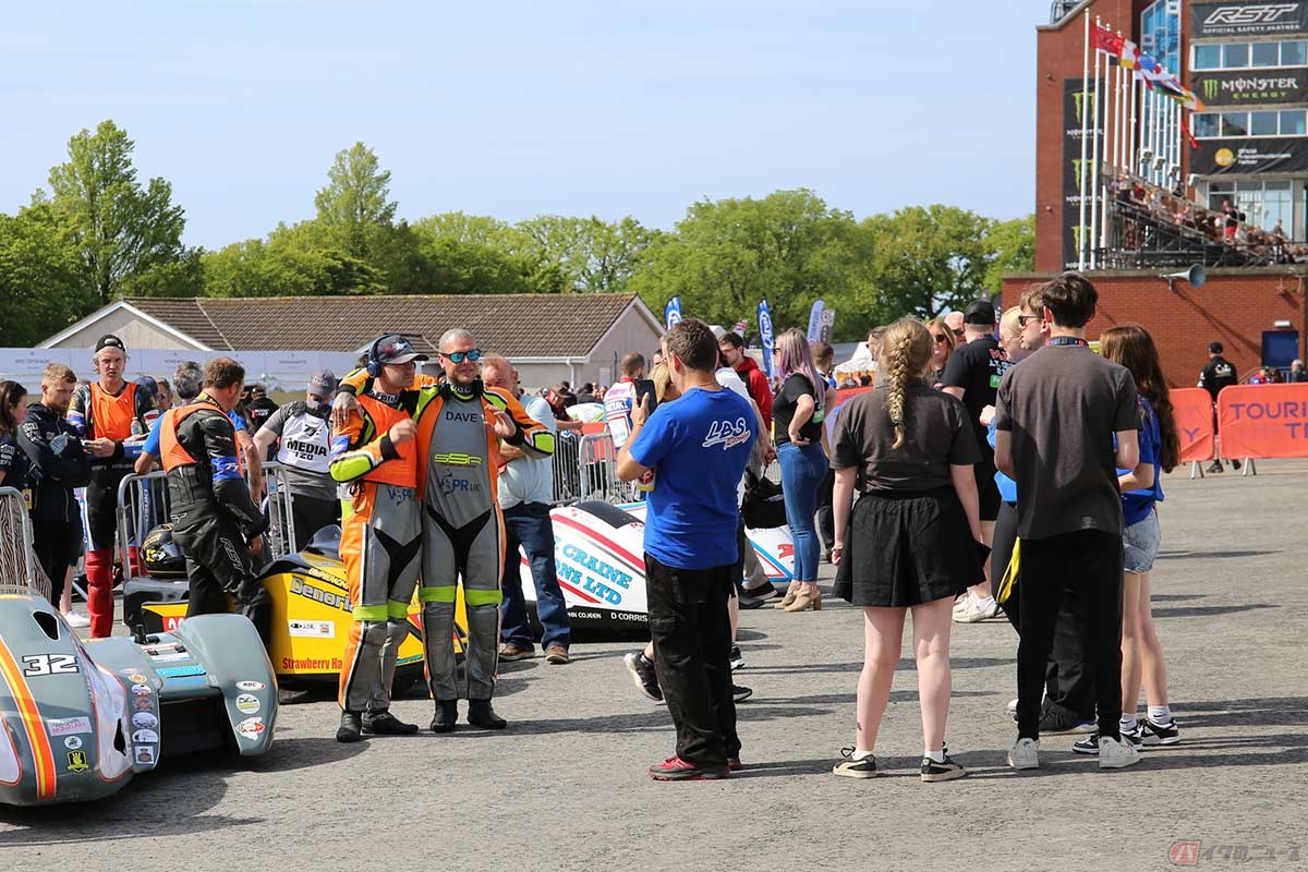 走行前のパドック。にこやかに談笑し、記念写真を撮る姿も。オレンジ色のベストはニューカマー（初参戦）に義務づけられている装備（写真／小林ゆき）