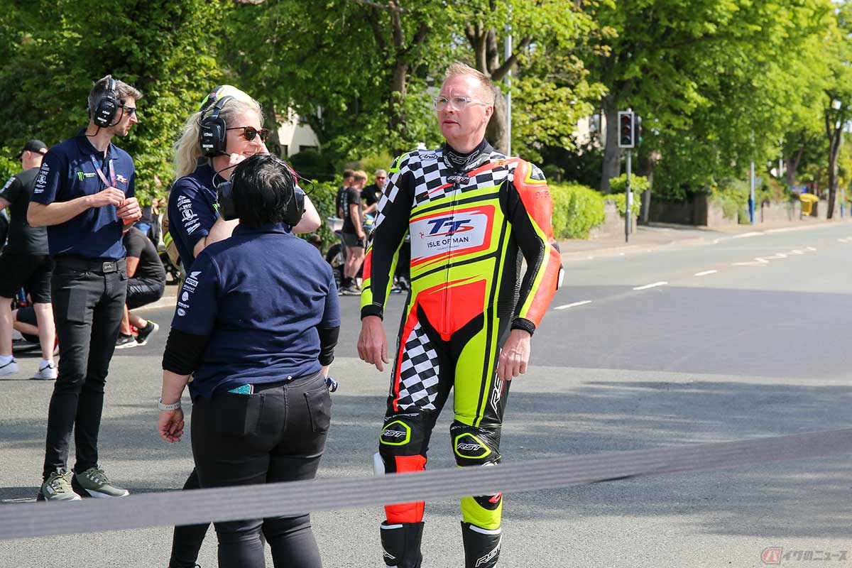 ライダー・リエゾン（ライダーと主催者との調整役）担当の「ミルキー」ことリチャード・クェールさん。地元マン島在住の元TTライダーで、今年は新しいデザインのツナギで先導走行に登場した（写真／小林ゆき）