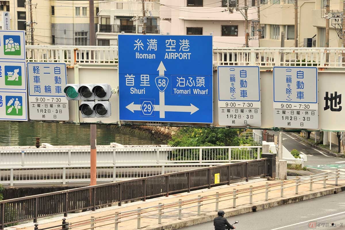 国道58号「泊交差点」歩道橋に設置された「バイクは第1通行帯しか走れない」ことを表す規制標識。走行できる車種は、各通行帯の上に設置された標識に表示されている