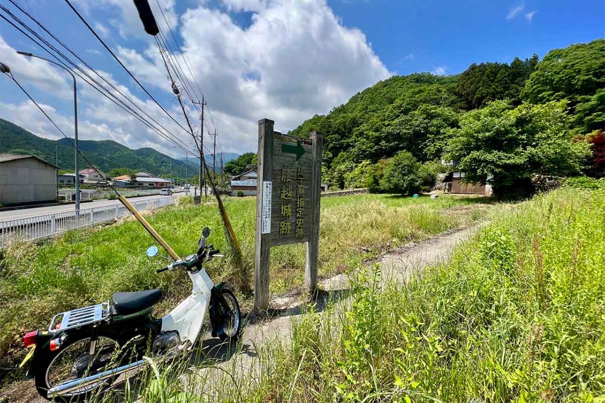 埼玉県小川町を流れる槻川（つきかわ）の近く、県道11号沿いに「腰越城跡」の登城口がある。看板に「パトリアへもお越しください」と書かれているように、バイクや車はパトリアの駐車場を使わせてもらうのが良さそうだ