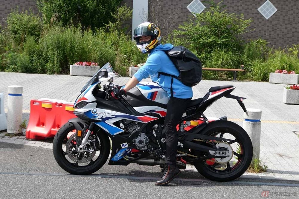 BMW Motorrad「M1000RR」に跨る石塚健選手。身長165cmだとかかとが浮いてしまうが、つま先は接地するので不安はありません。