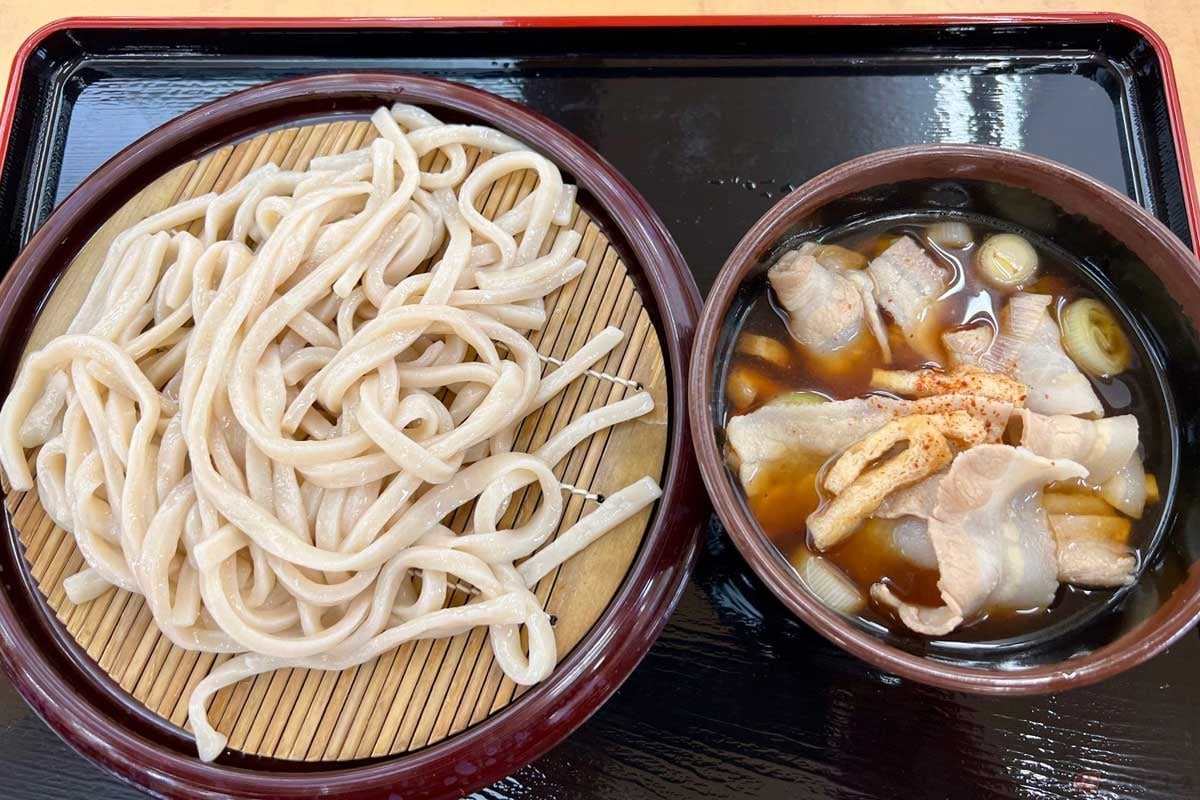 関越道「高坂SA」(上り)で食した「肉汁うどん」(850円)。ツルツルでコシのある太いうどんを、温かい甘めの肉汁につけて食べる「武蔵野うどん」。冷たい麺と温かい汁の組み合わせが絶妙