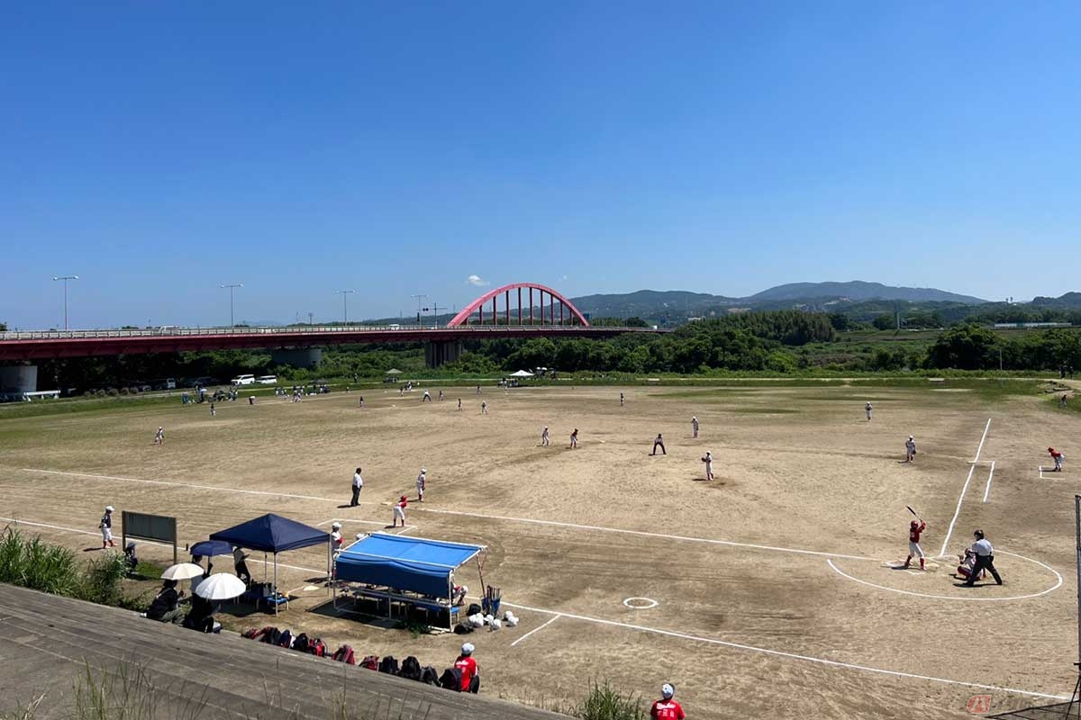 のどかな風景が広がる河川敷の光景。少年たちが野球に熱中していた