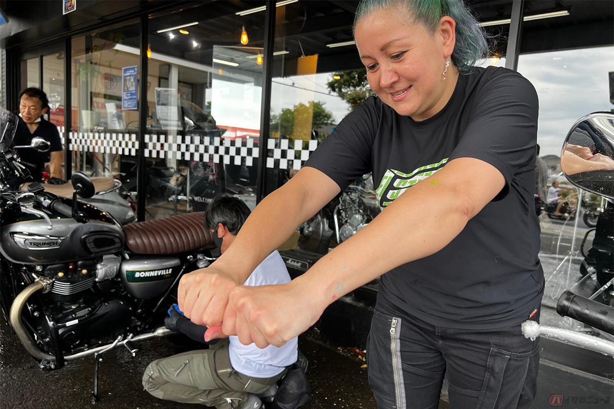 タオルを絞りながらバイクの拭き上げをするクリステル・チアリさん