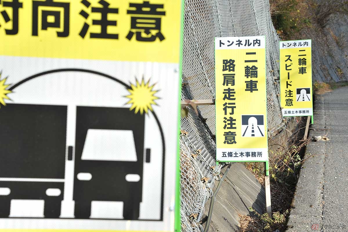 国道168号「助人トンネル」付近に設置された注意看板。バイクの路肩走行注意とは、どんな意味があるのか。対向注意がかすむ（撮影／中島みなみ）