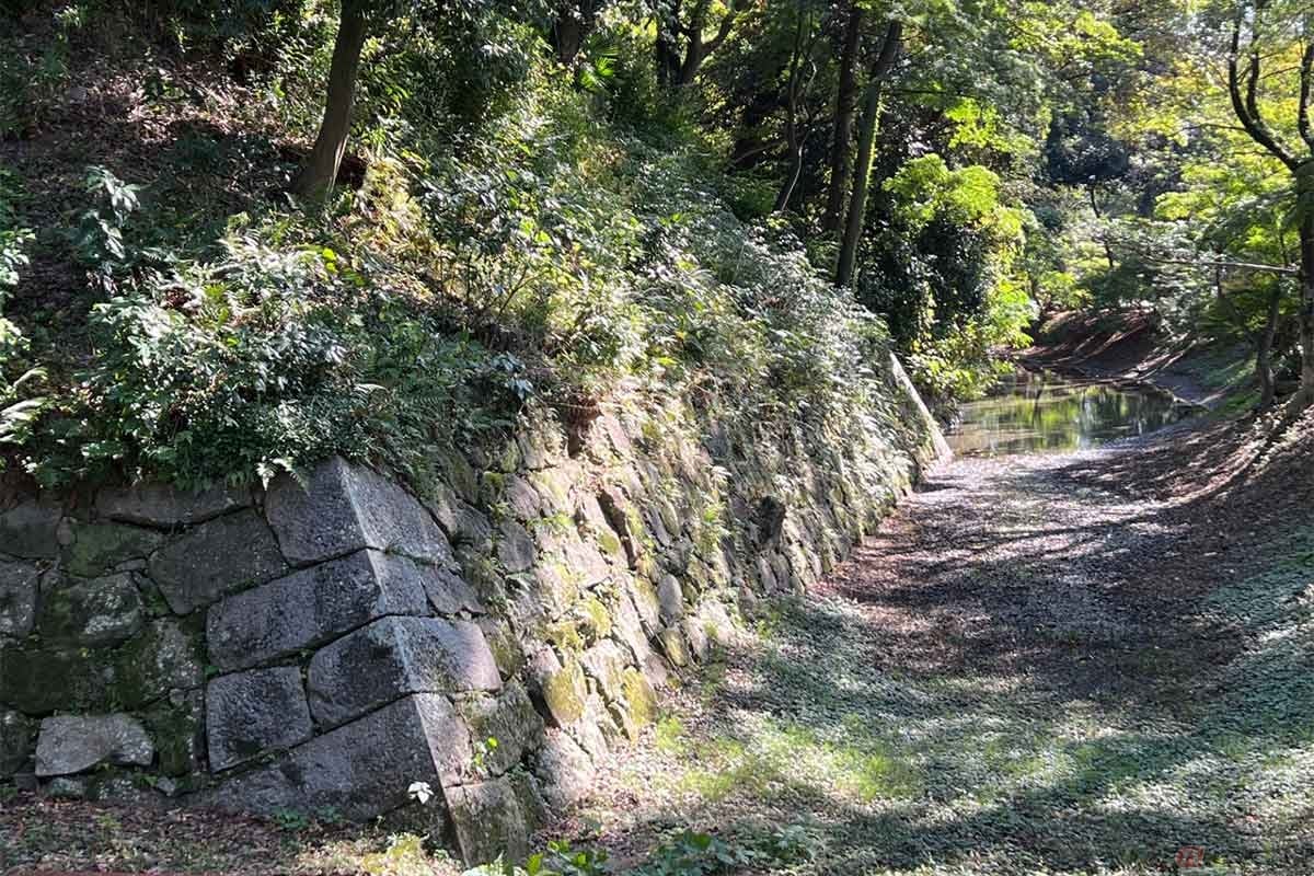 「持仏堂曲輪腰巻石垣(じぶつどうくるわこしまきいしがき)」は、江戸時代前期に構築された石垣。角は長辺と短辺が交互に配置された算木積み(さんぎづみ)。ノミの跡も見られる