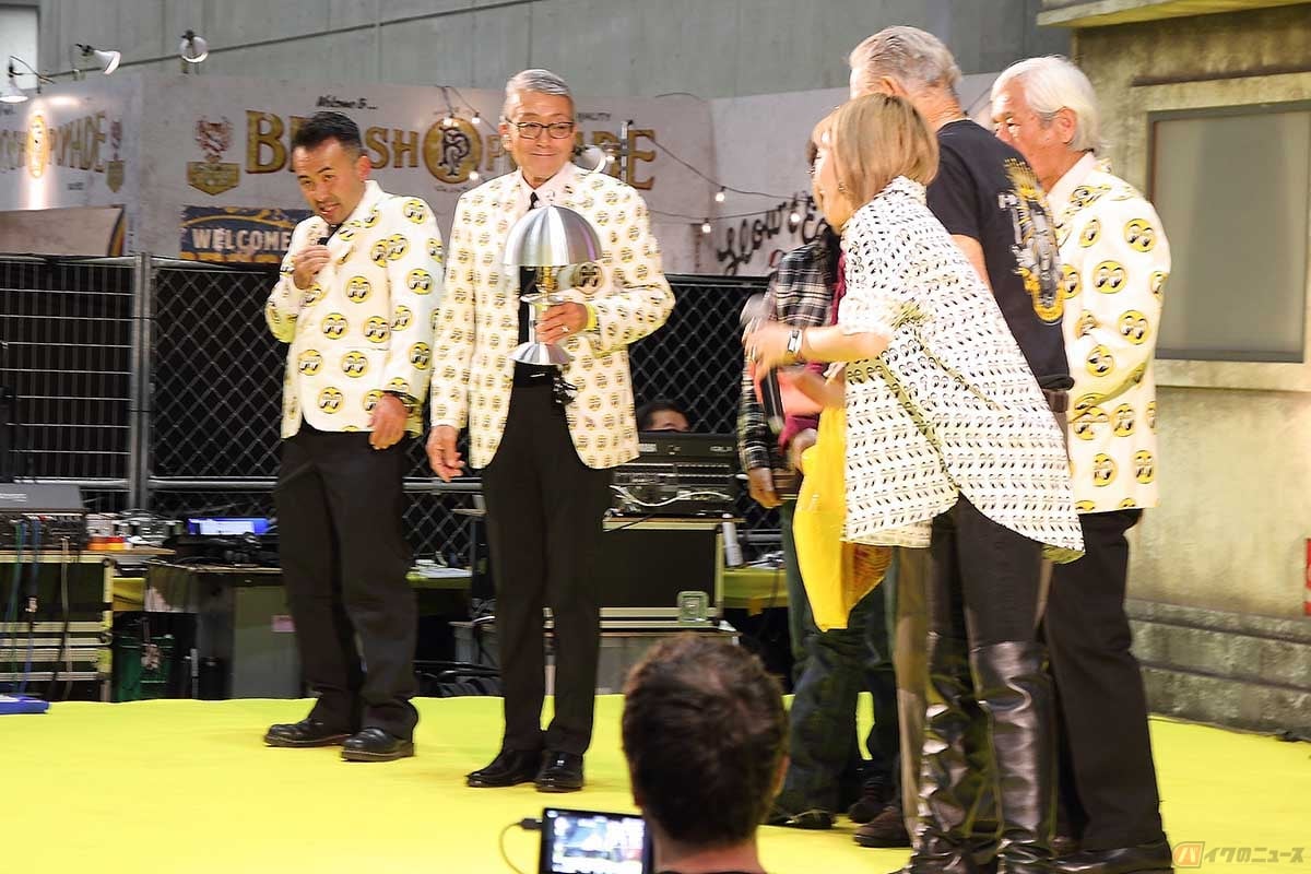 我が国最大のアメリカン・カスタムショーを主催するムーンアイズの代表、Shige Suganuma氏(写真左から2人目の人物)。クルマやバイクを垣根なく盛り上げ、カスタム業界を牽引する人物です