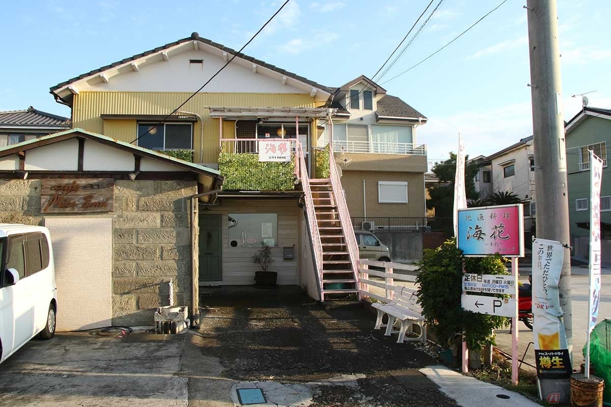 横須賀市、長井新宿漁港が目の前に広がる海沿いの通りに面した「地魚料理 海花」。お店はどこ? と探すと、黄色い建物の2階だった