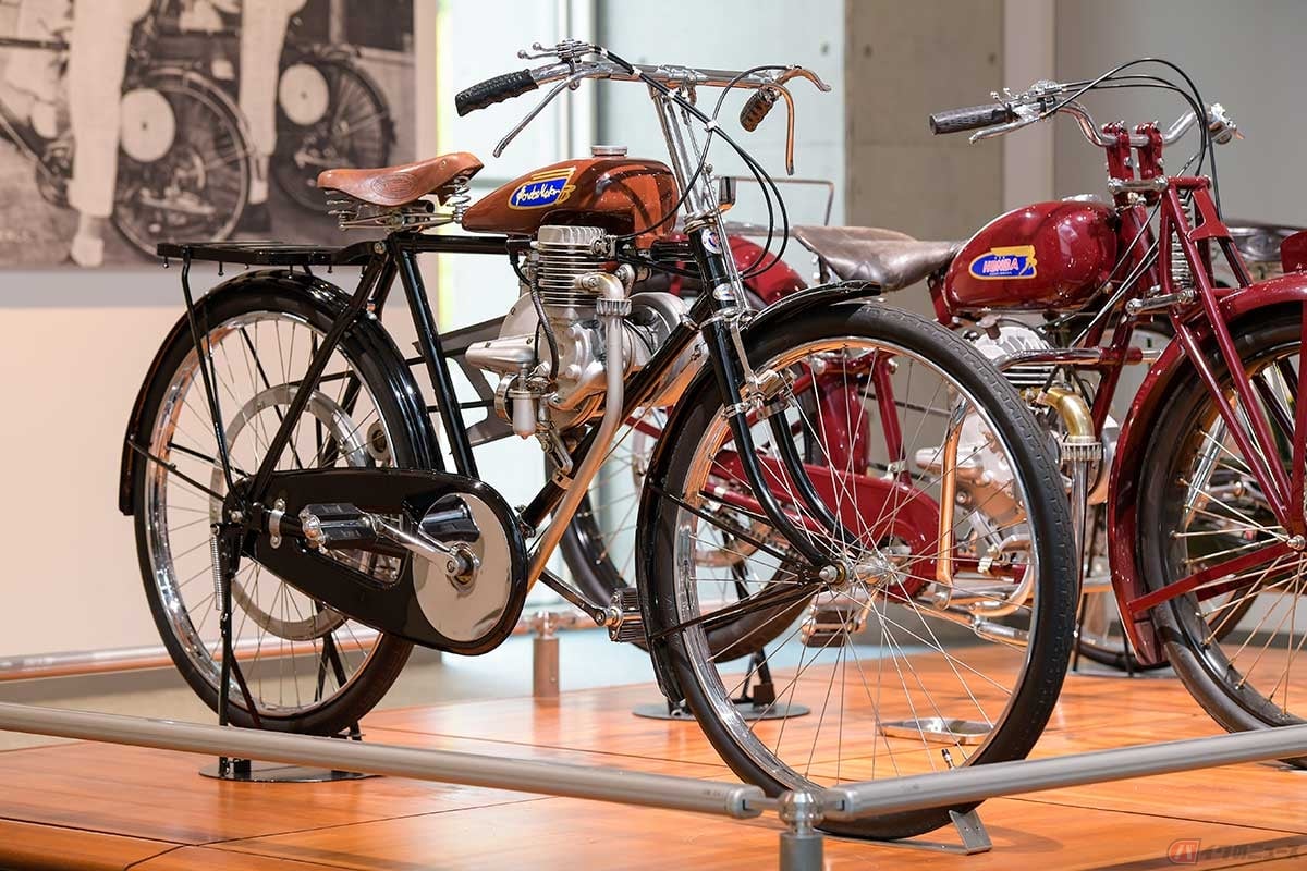 自転車に取り付ける補助エンジンの「ホンダA型」は、ペダルを漕いでクラッチを繋ぐとエンジンが始動し、バイクのように走ることができる