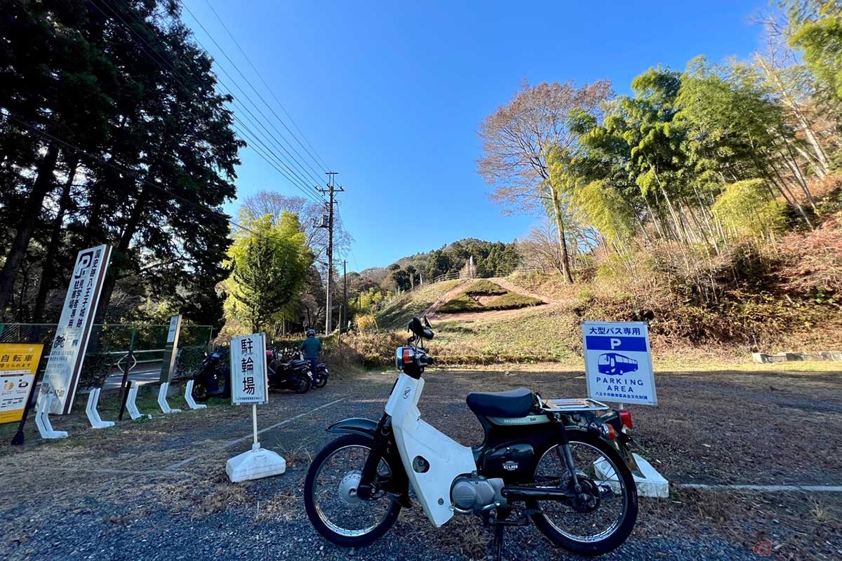 スーパーカブで「八王子城跡」へ。大型バスやクルマの駐車場が広く確保されているなか、2輪用のスペースもあるのはありがたい
