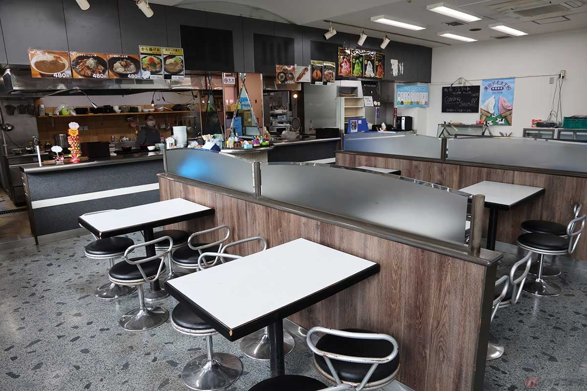 「レストハウス逗葉」のメニューは、うどん・そば、ラーメンなど麺類が多い。逗子駅近くの閉店したラーメン屋の看板があったので、同じラーメンが食べられるのかも? 店内奥のカウンターではジェラートやソフトクリーム、カレーパンなども販売中