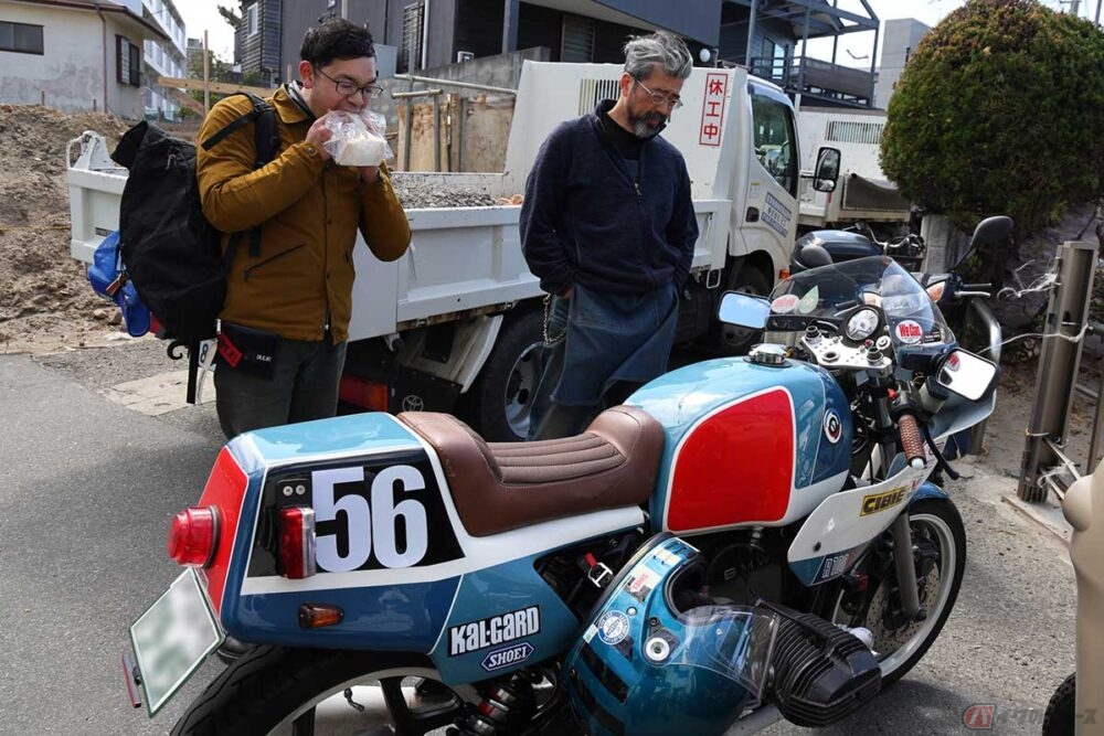 「FLAT FISH」の「アジフライサンド」を購入した「うおへい商店」常連ライダーと店主の和田さん（右）。ここには個性的なバイクがたくさんやってくる