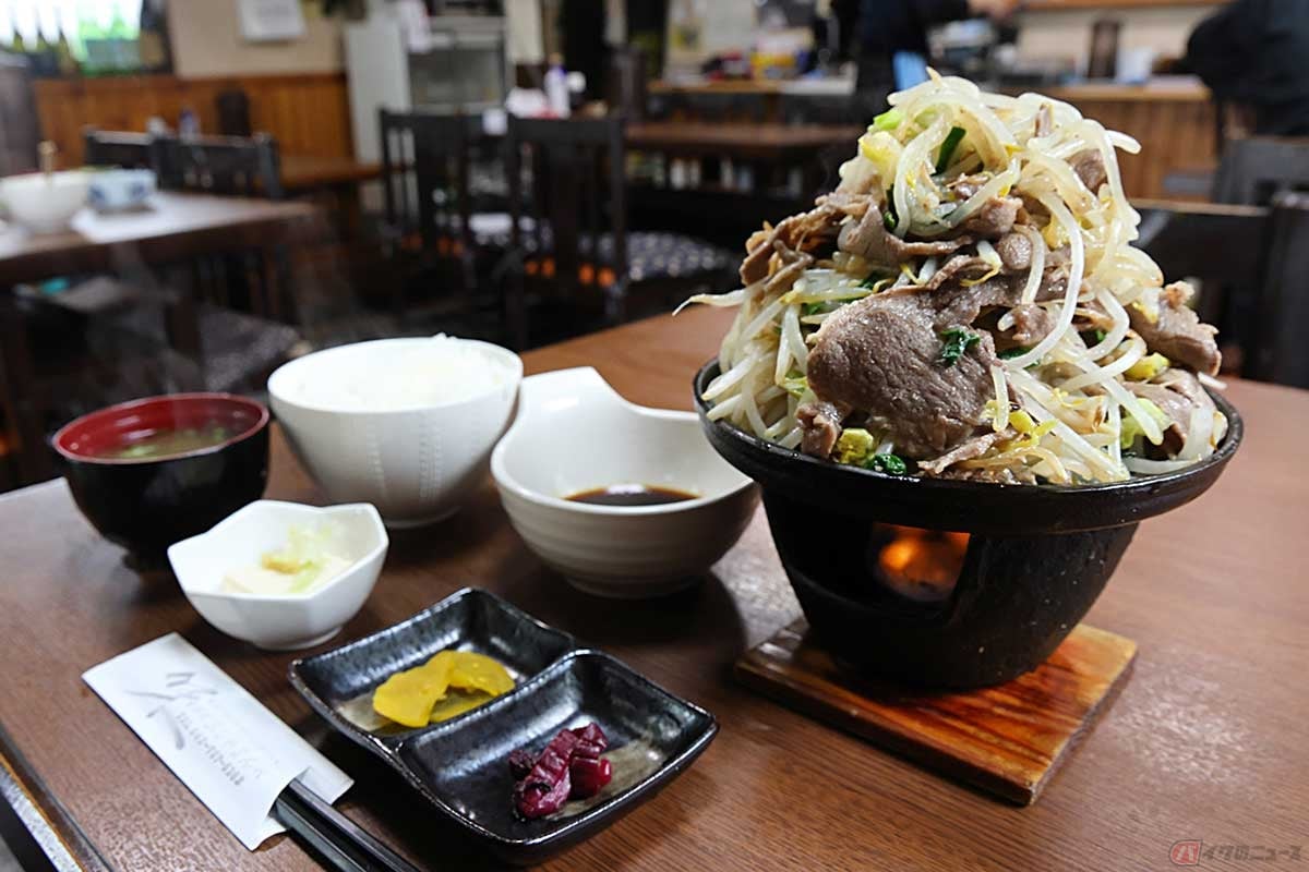 「食事処 おしゃまんべ」で1番人気の「ジンギスカン定食」。盛りがすごいジンギスカンにご飯と味噌汁、小鉢(冷奴)、漬物が付く