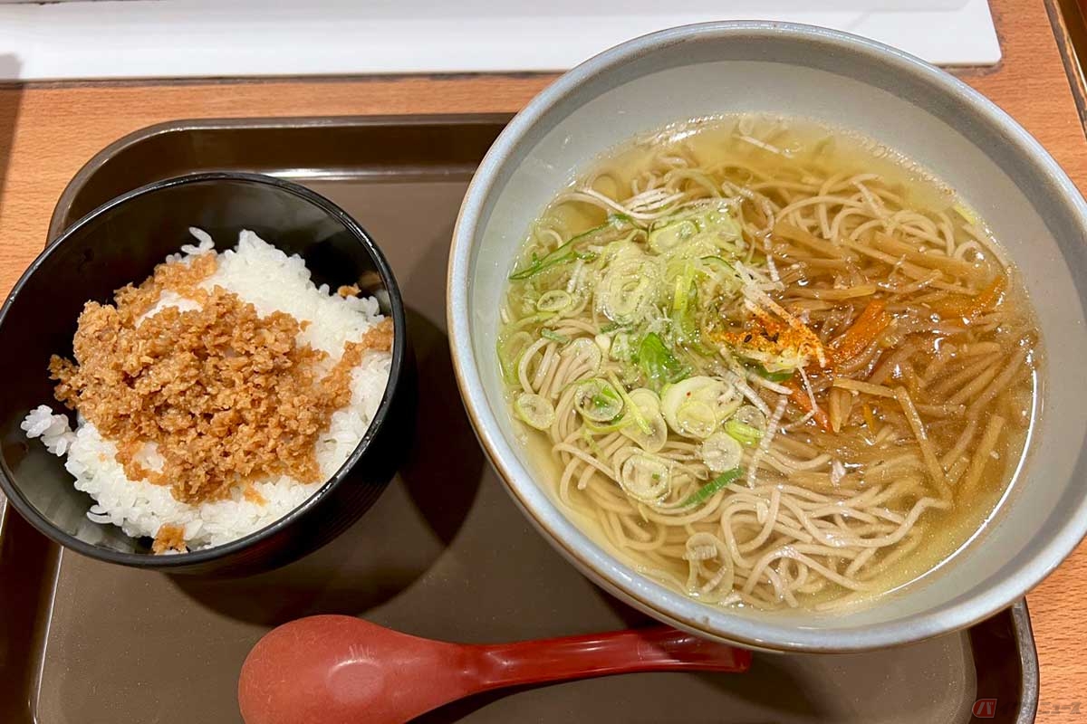 東名高速「港北PA」(下り)でいただく「そば・ミニそぼろ」(950円)のそばは、丼の底まで透けて見えるくらい色が薄いつゆと、刻みネギと一緒にきんぴらごぼうが入っている個性派