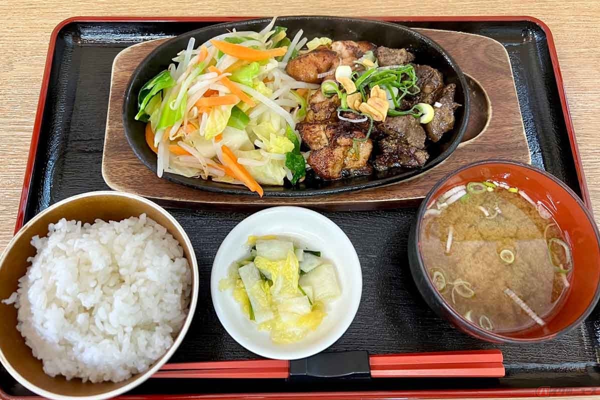 中国自動車道「真庭PA」(上り)の「まにわご飯レバテキ定食」(1050円)は、熱々の鉄板の上で鶏肉と鶏レバーがジュージュー音を立てながら出来上がってきた。白飯に味噌汁、白菜の漬物という組み合わせ。さっぱりした漬物がありがたい