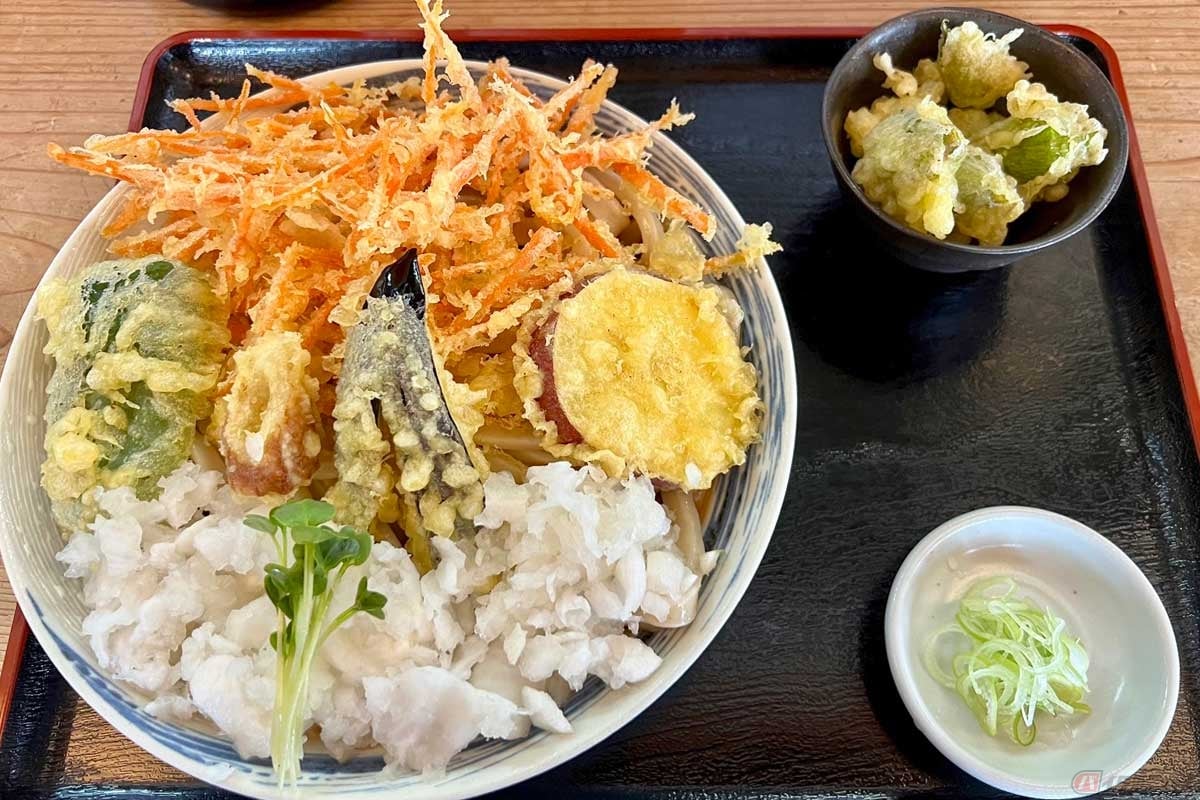 新鮮な野菜の天ぷらと大根の「鬼おろし」で彩られた「冷やしたぬきうどん」。さらに「旬の天ぷら(ねぎ坊主)」も追加