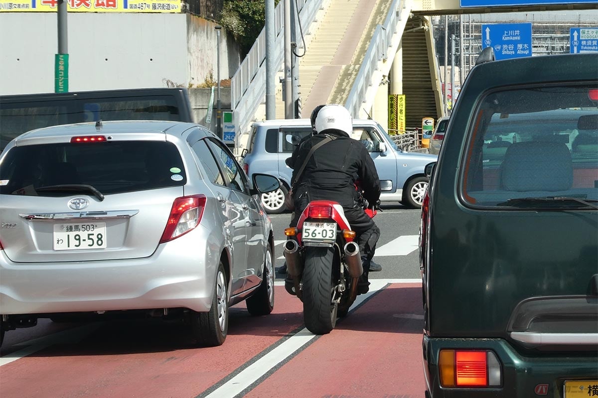 「すり抜け」は、渋滞している道路や信号待ちをしているクルマの横を走行し、交差点の先頭にでるなどの行為