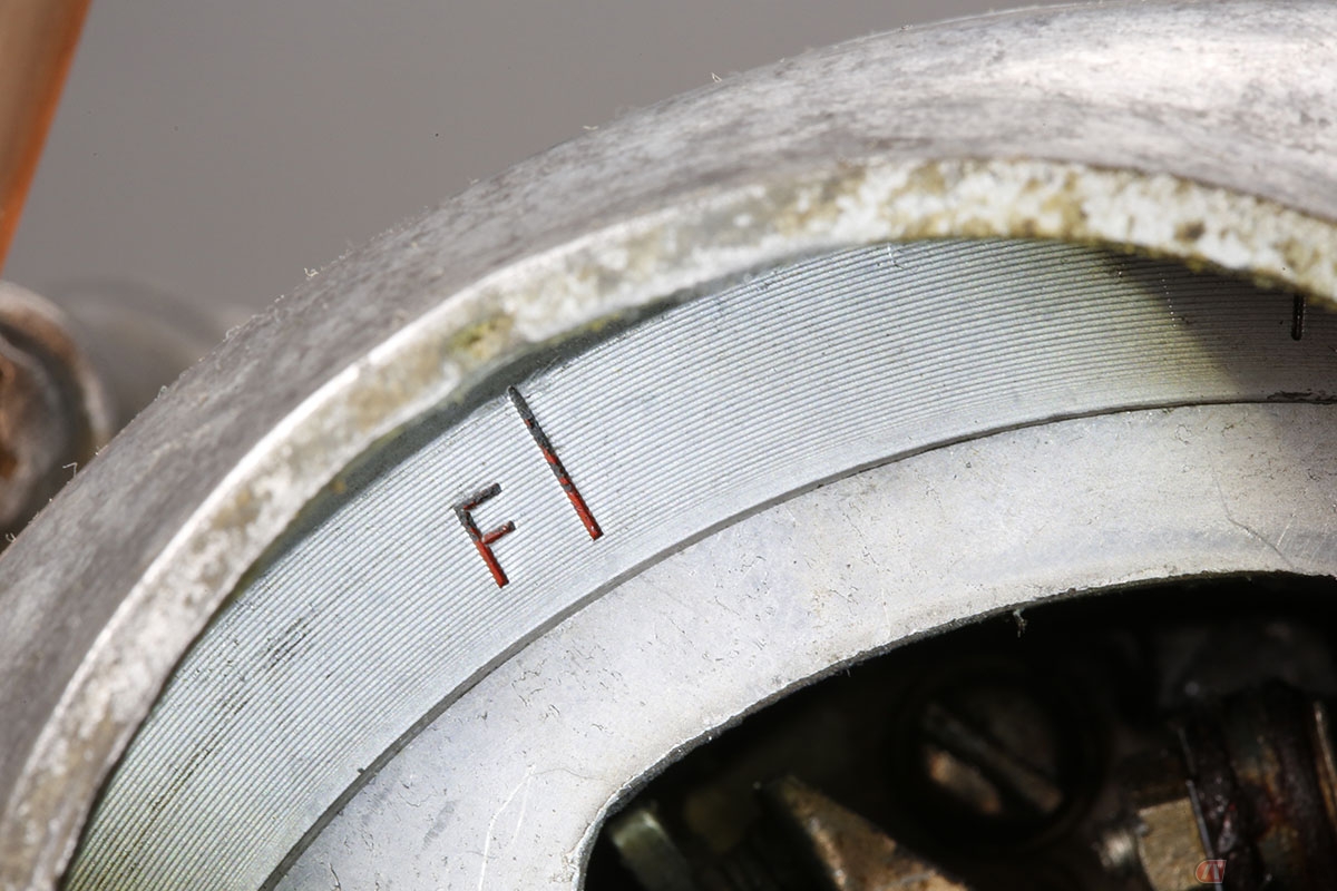 フライホイールの外周にあるF刻線(点火＝〝ファイア″の意味)がクランクケース側の刻線を通過するのと同時にポイントが開くように目視調整。C100はポイントギャップを0.4mmに調整すれば、おのずと点火タイミングが良い位置に来るような機械的設計となっています