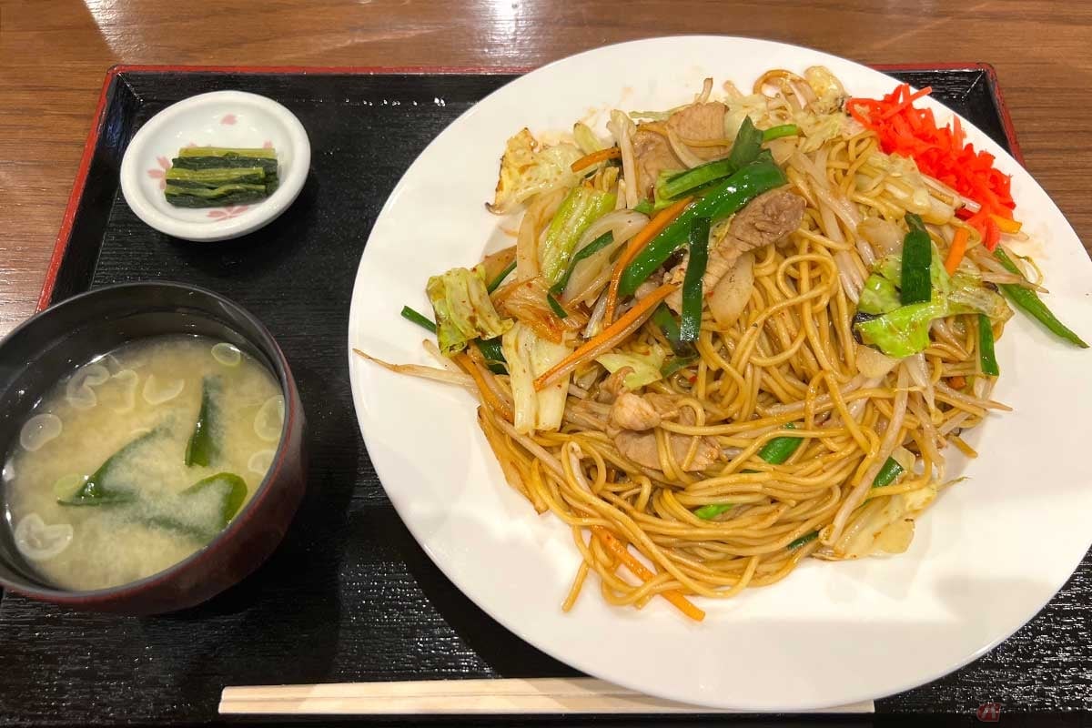 中央道「釈迦堂PA」(上り)で注文した「野菜たっぷりジャンボ豚キムチ焼きそば」(800円)。豚キムチのビタミンB群は長距離ライディングで疲れた体にもぴったりでたくさんの野菜も嬉しい。味は少々薄めでモリモリ食べられる。味噌汁・漬物付