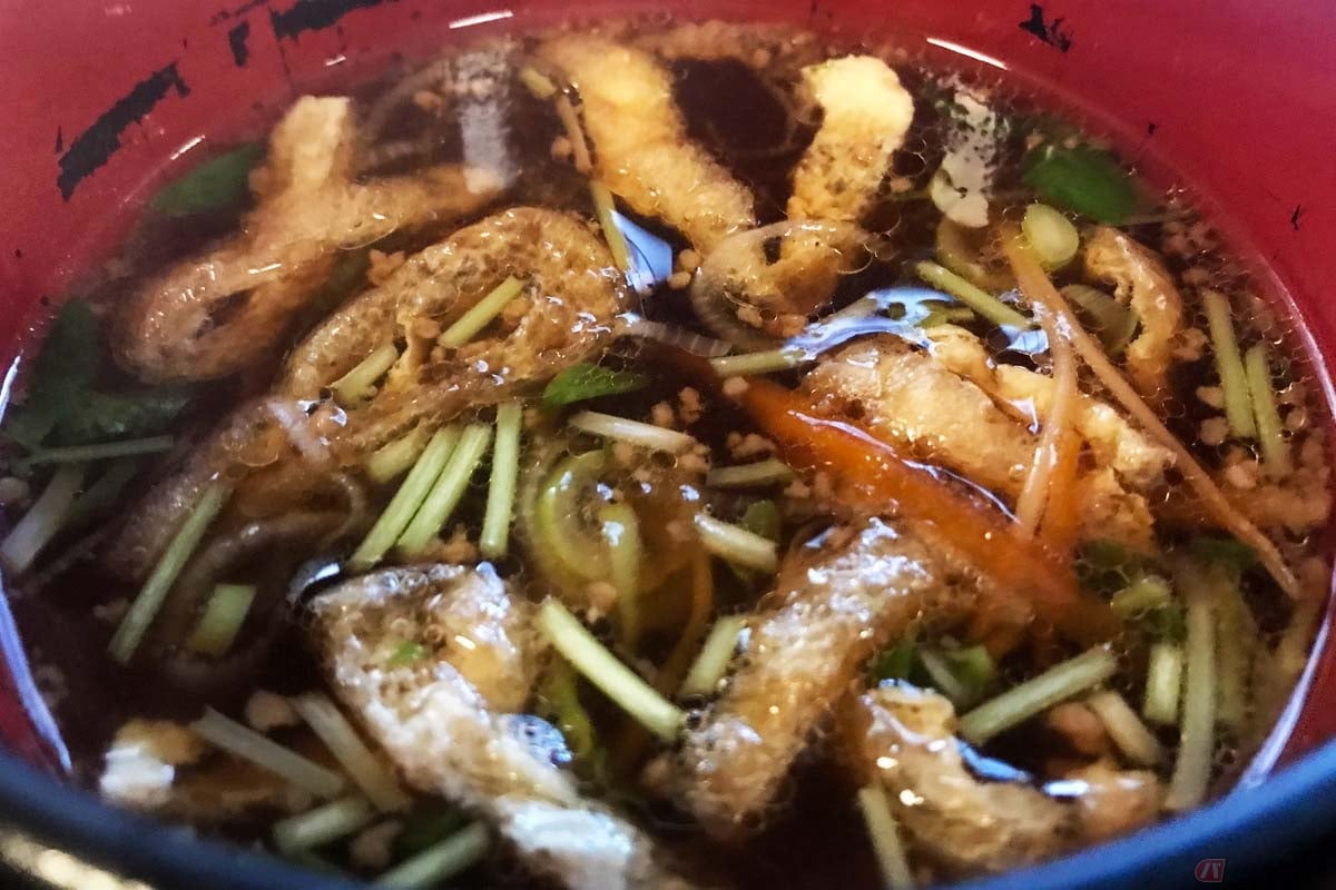 カツオ出汁の効いたしょうゆベースのつゆ。ひき肉、油揚げ、長ネギ、水菜、ニンジンなどが入っています