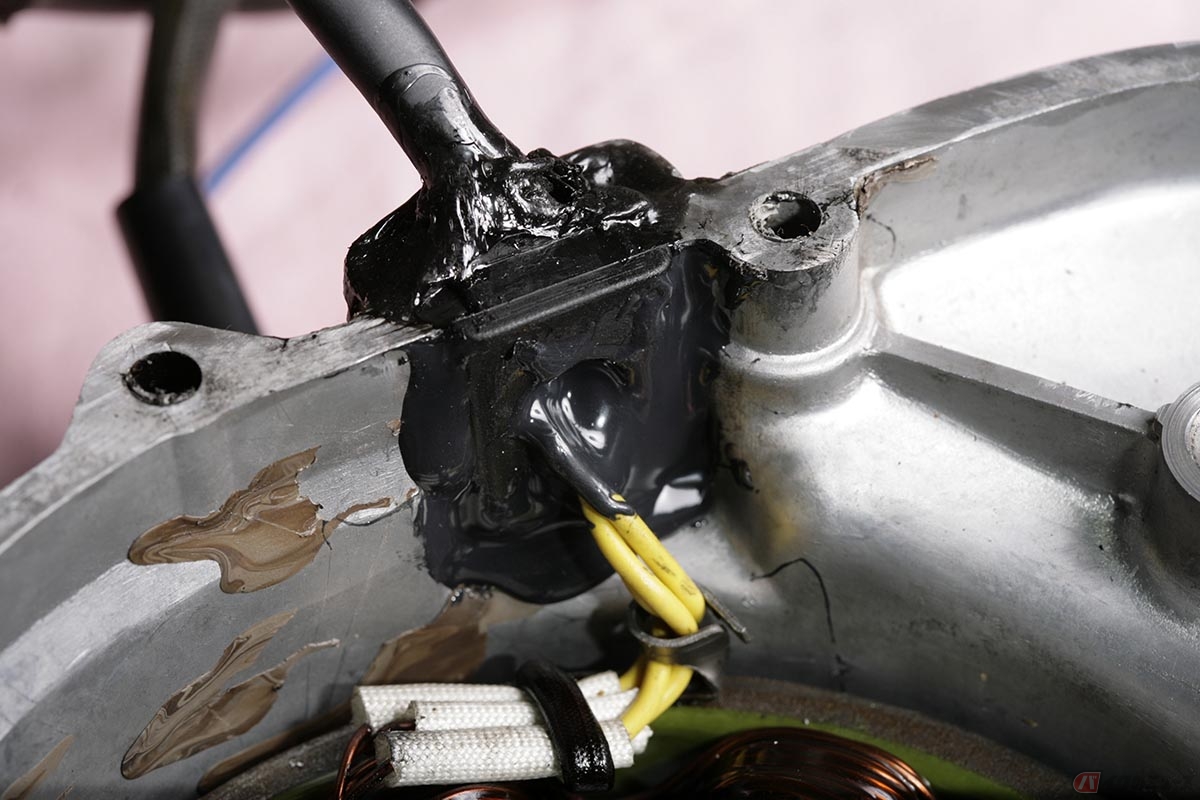 グロメットだけではなく周辺も含めてしつかり脱脂洗浄した後に、内側は「スーパーX」接着剤で封じ込めます。配線を取り回す空間部分へは、シリコン系液状ガスケット{スリーボンドの1103黒}を流し込んで、グロメットの前後を完全に封じました