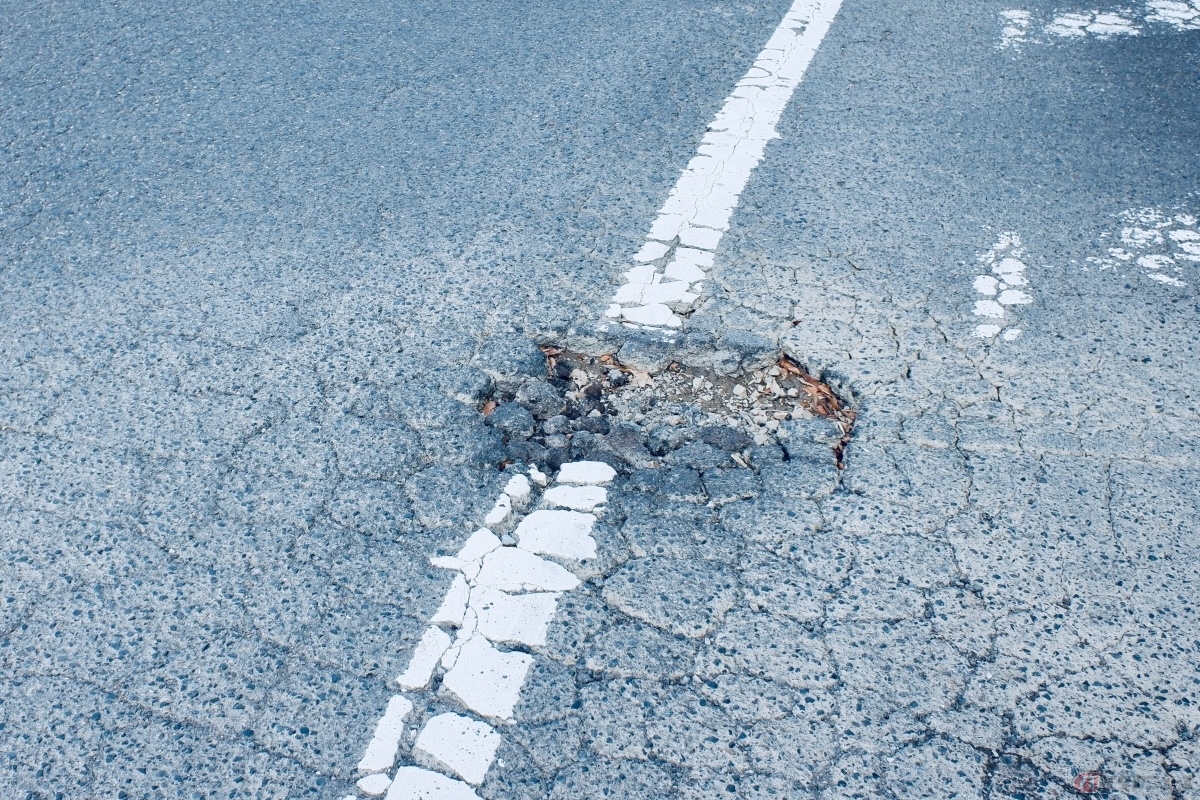 急通報に該当する道路の異状として「道路の穴ぼこ、路肩の崩壊などの道路損傷、落下物や路面の汚れ」などがある