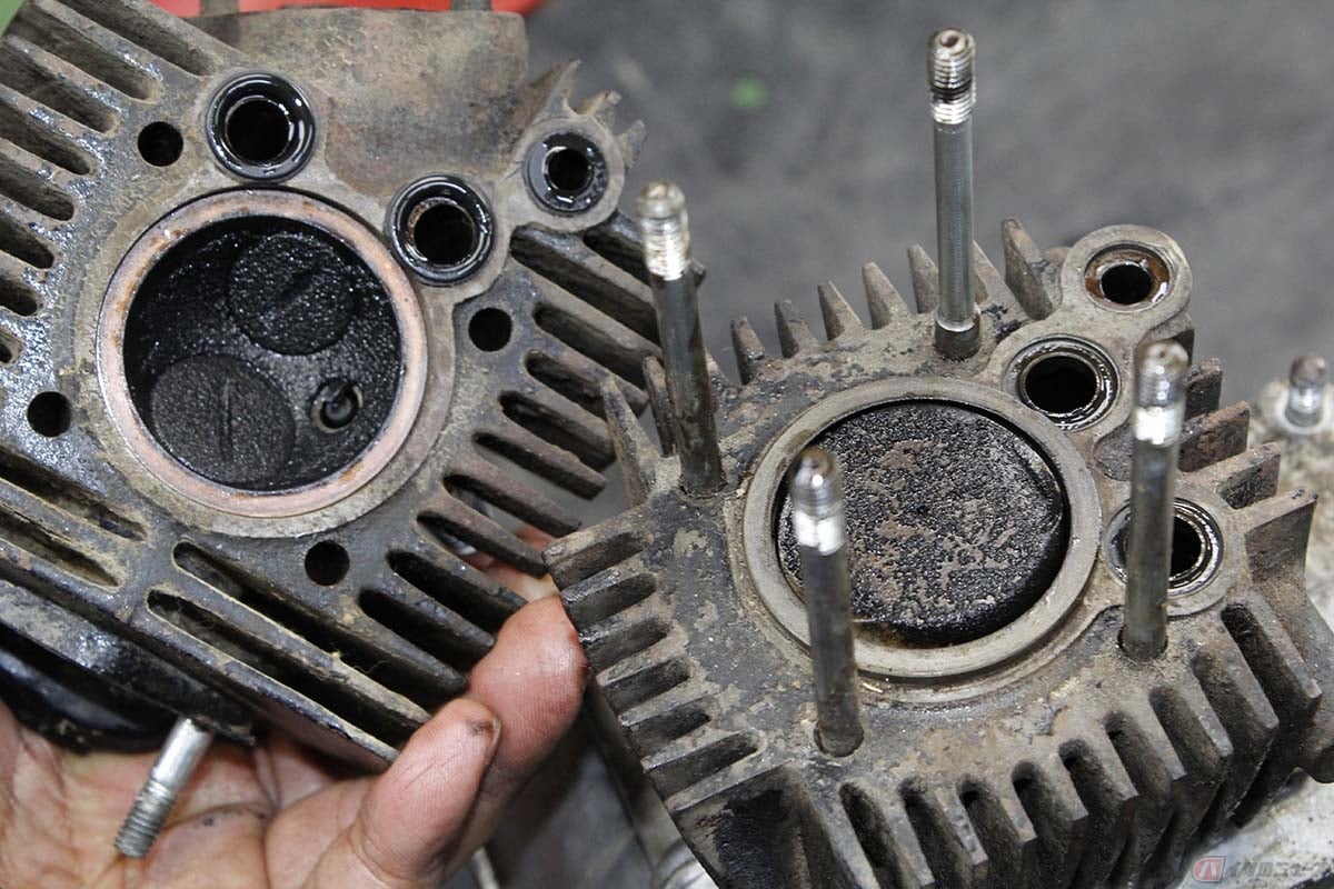 シリンダーヘッドを取り外すと、上死点にあるピストントップと燃焼室内に堆積したカーボンの様子を確認できます。いずれもコゲ付いたような印象ではなく、オイルにまみれながらカーボン堆積している様子が見て取れます。こんな燃焼状況だから、白煙モクモクだったのですね