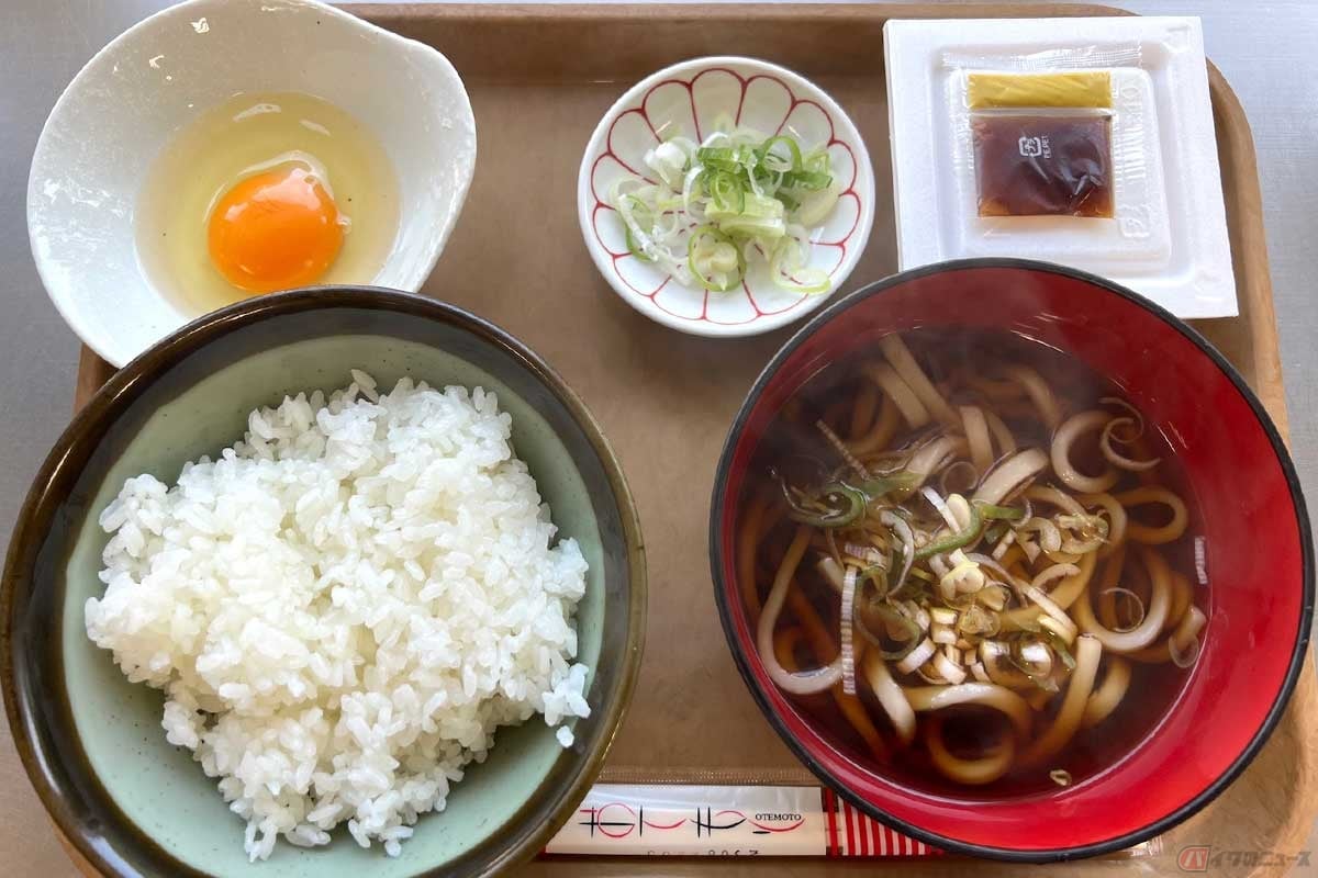 中央道富士吉田線「谷村PA」(下り)の「納豆朝定食」(600円)は、味噌汁ではなくかけうどんが並ぶ。濃い色のつゆでごはんのおかず(?)にも汁物の代わりにもなり、これはこれで良い