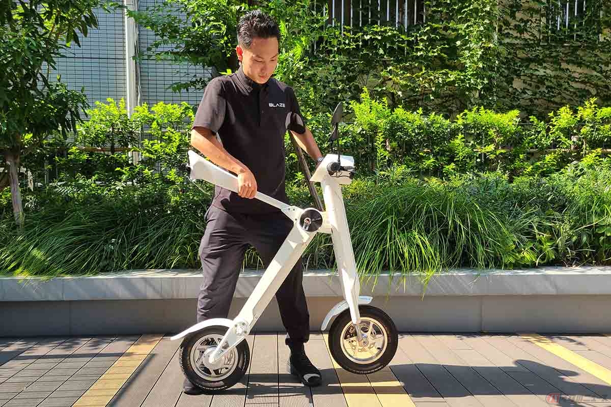 ブレイズの新型モデル「スマートEV特定原付モデル」。折り畳み手順① シートを持ち上げるとフロント側が手前に移動。ハンドルはクイックレバーで簡単に折り畳めます