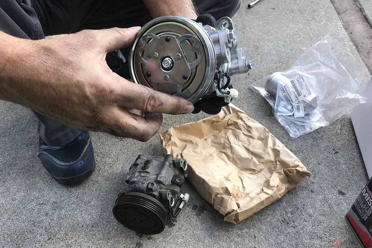 冷媒ガスを回収した後に旧コンプレッサーを取り外してリビルド品と比較しました。手で回すプーリーの抵抗感と音は、リビルド品と大違い!!　手で回しただけでもその違いは明確でした。なにしろ走行中に発する異音が怖かったほどです