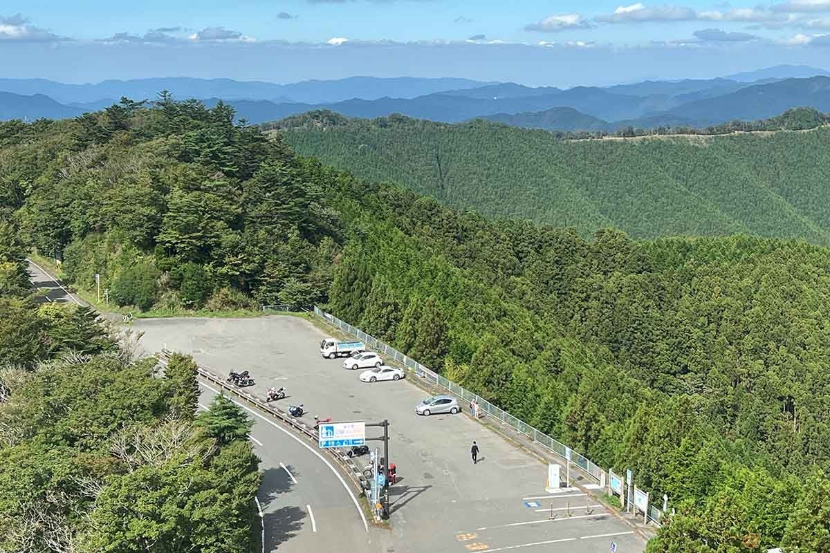 「道の駅 ごまさんスカイタワー」のスカイタワーから駐車場を見下ろします。遠くには峰々が連なり、山深さを実感できます