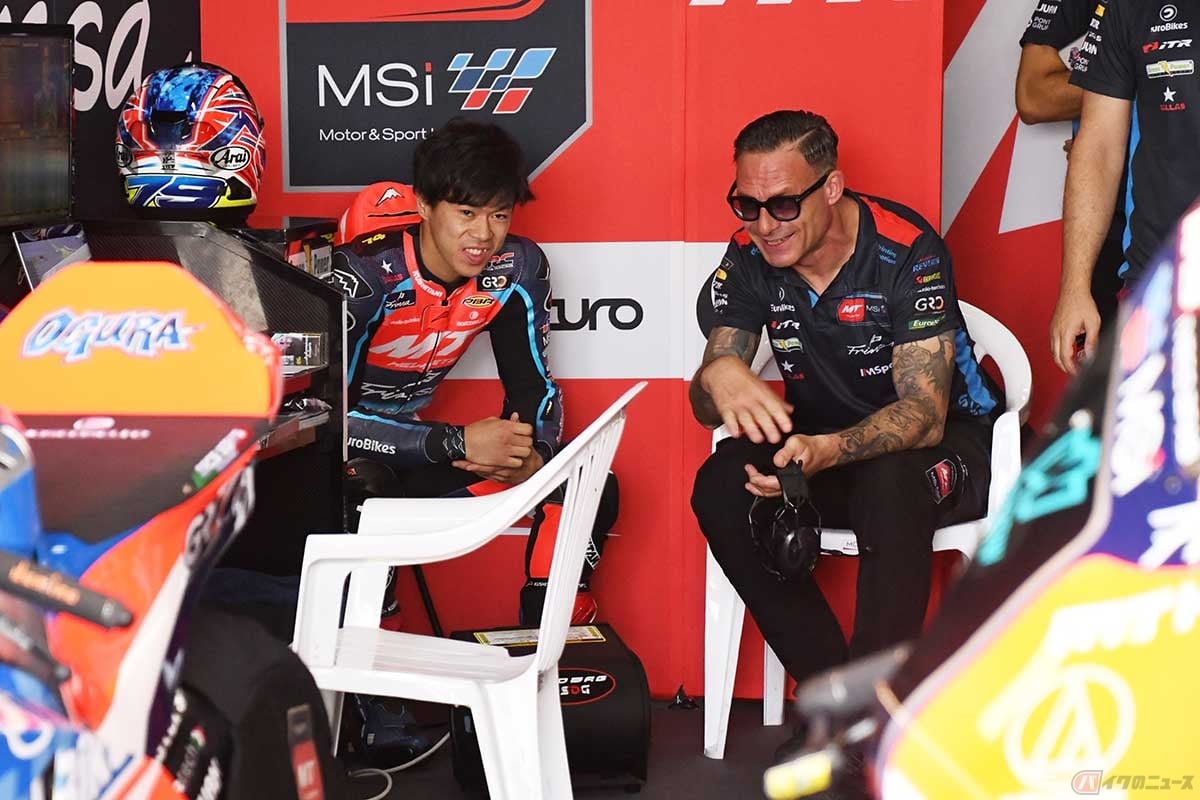 MotoGP第18戦タイGPの週末は、ピットで笑顔を見せることもあった小椋選手。このときもノーマン・ランクさん(右)と話しながら笑みを浮かべていた
