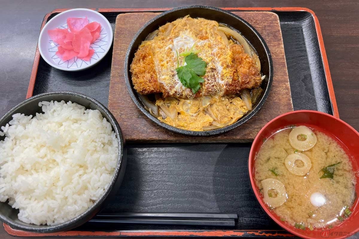 常磐道「美野里PA」(上り)で注文した「かつ鍋定食」(1150円)は、見た目も美しく食欲をそそる。溶き玉子の黄色と桜色の漬物のコントラストも鮮やか