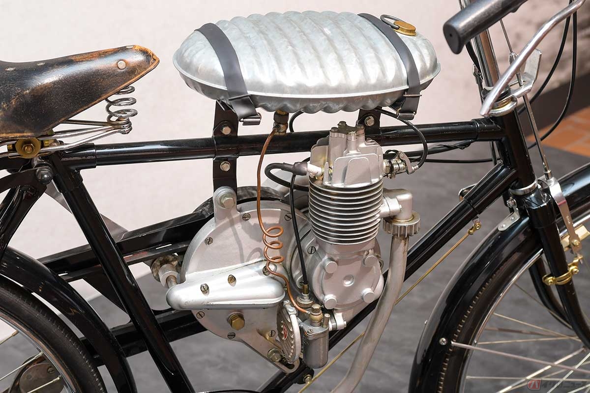 1947年に作られたホンダ初の自社製エンジン(プロトタイプ)、凸型ピストンを採用する通称「エントツエンジン」は自転車用補助エンジンとして開発され、エンジン下部から混合気を吸入するロータリーバブル式を採用。市販化はされず、湯たんぽが燃料タンクとして使用された