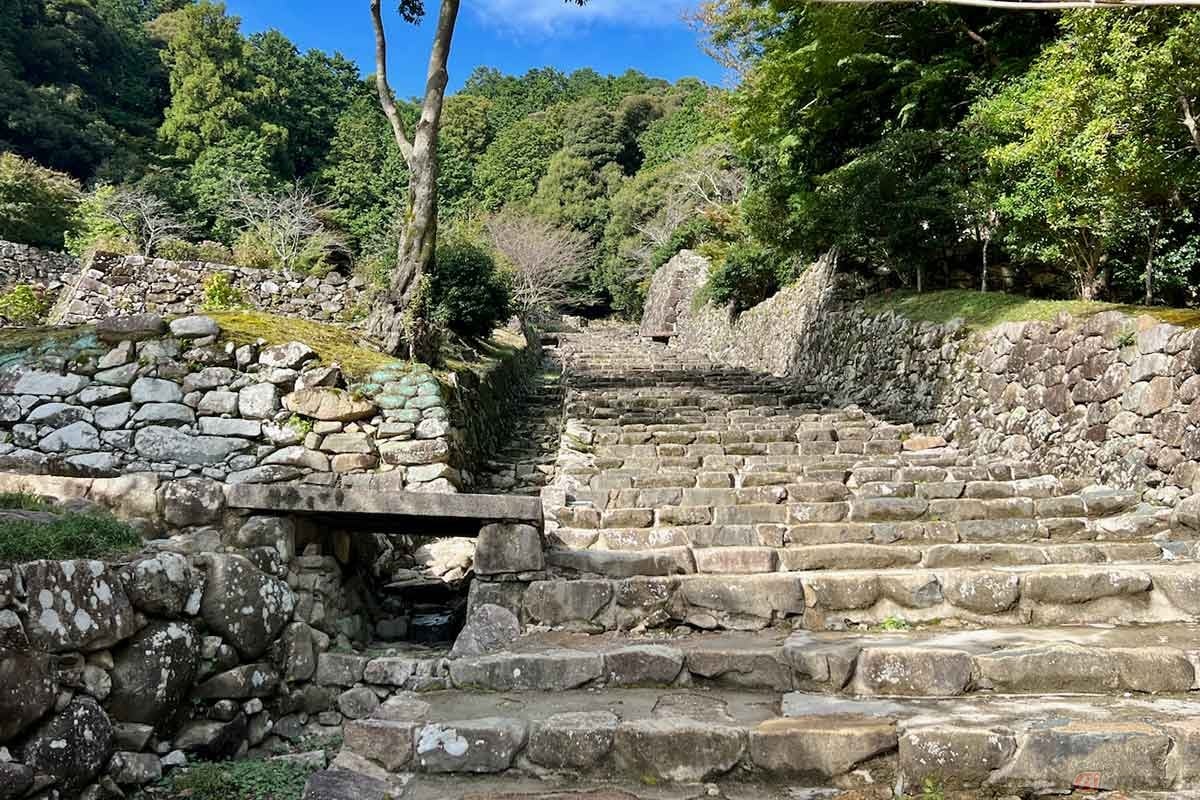 真っ直ぐに伸び、最後は曲がりくねりながら本丸へ向かう「大手道」。天皇が通るための道は普段は使われることなく、街道から見える直線的な「大手道」とその先の天主は威容を放っていたに違いない