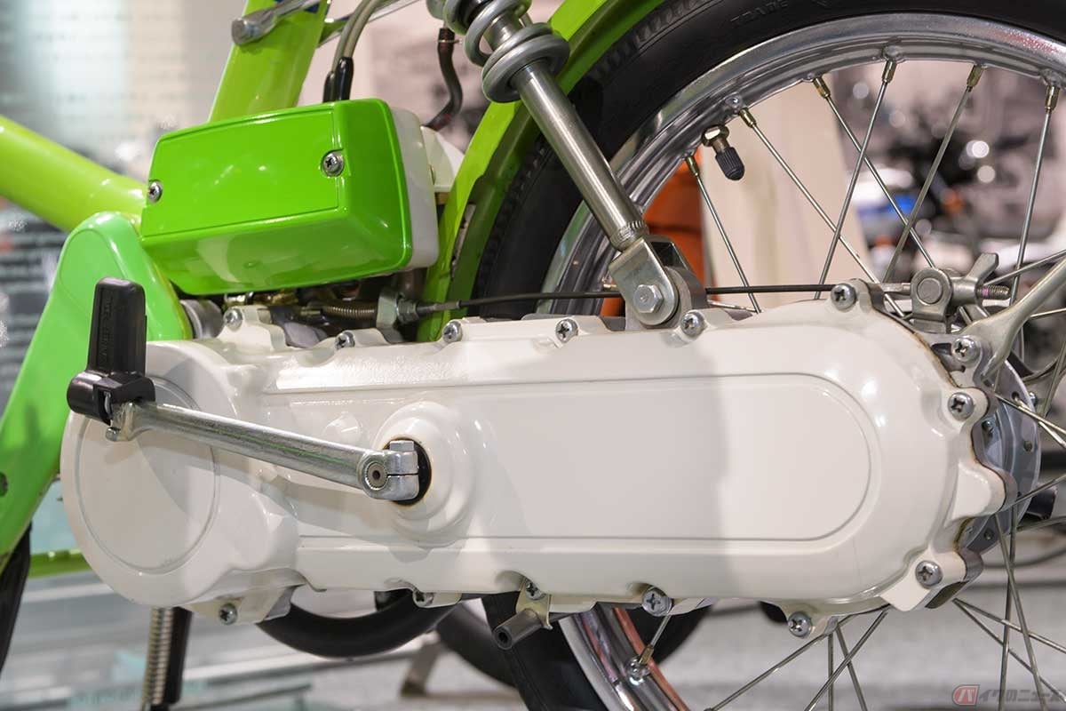 車体左側後部のスイングアームに見えるケースの中に、チェーン駆動のユニットと始動用ゼンマイが収まっており、側面に生えたペダルをつま先で「ラッタッタ~♪」(CMの演出)の掛け声とともに踏み込むことでゼンマイが巻かれる