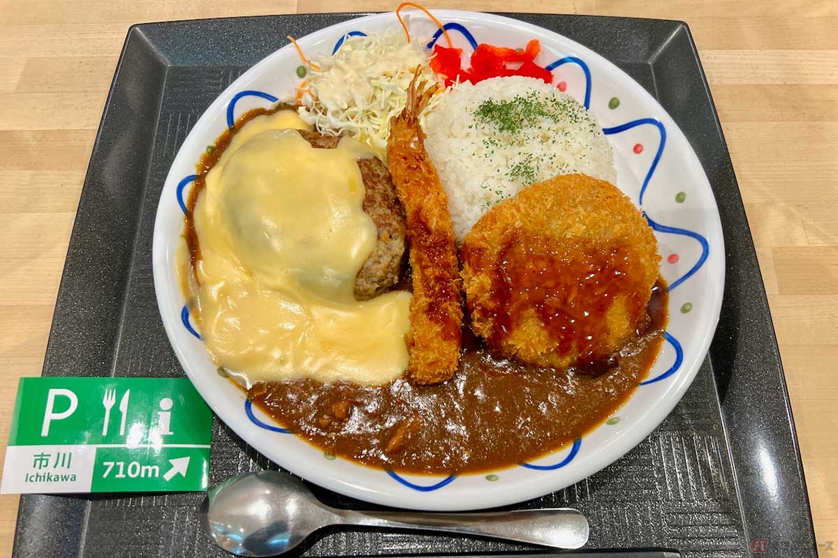 首都高「市川PA」の期間限定メニュー「背徳×とろけるチーズ わんぱく満腹ハンバーグ&MIXフライカレー」(1450円)は、一枚のプレートの上にライスやカレー、フライなどが盛られた夢の共演。これぞまさに「カロリーの大渋滞!」