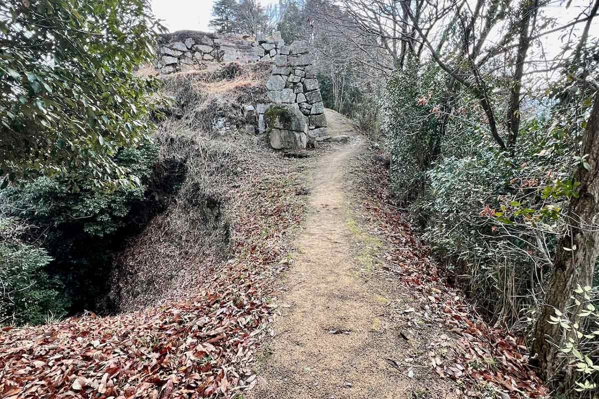 両端が抉られた土橋の向こうに石垣が見える。興奮して渡ったのは言うまでもない
