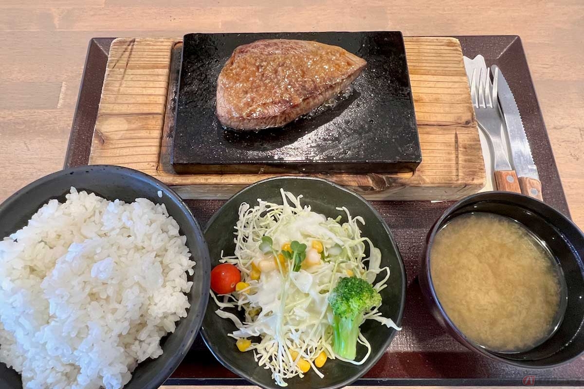 東名高速「駒門PA」（下り）で見つけた「溶岩焼き　ランプステーキ」（1300円）は、富士山の溶岩プレートで焼き上げる、いつまでも熱々のステーキ。ご飯は無料で大盛りに。サラダや味噌汁もセットでこの値段はコスパが高い。分厚いプレートはかなり重く、慎重にトレーを運んだ