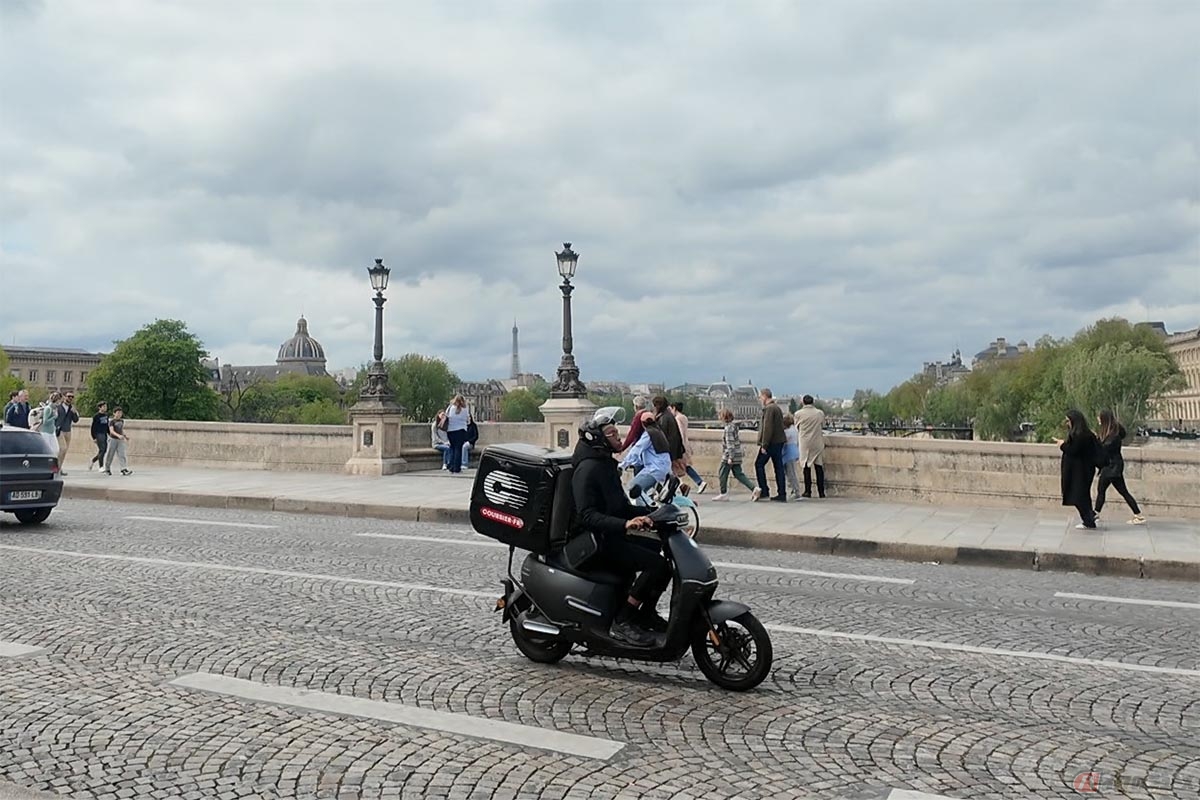 パリの石畳の上を走るスクーター
