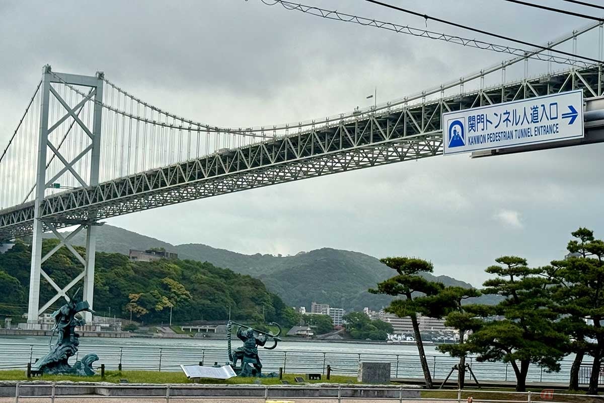 源平合戦「壇ノ浦の戦い」のモニュメントの上にかかる関門橋。向こうには関門海峡と、対岸の福岡県門司の陸地が見えます