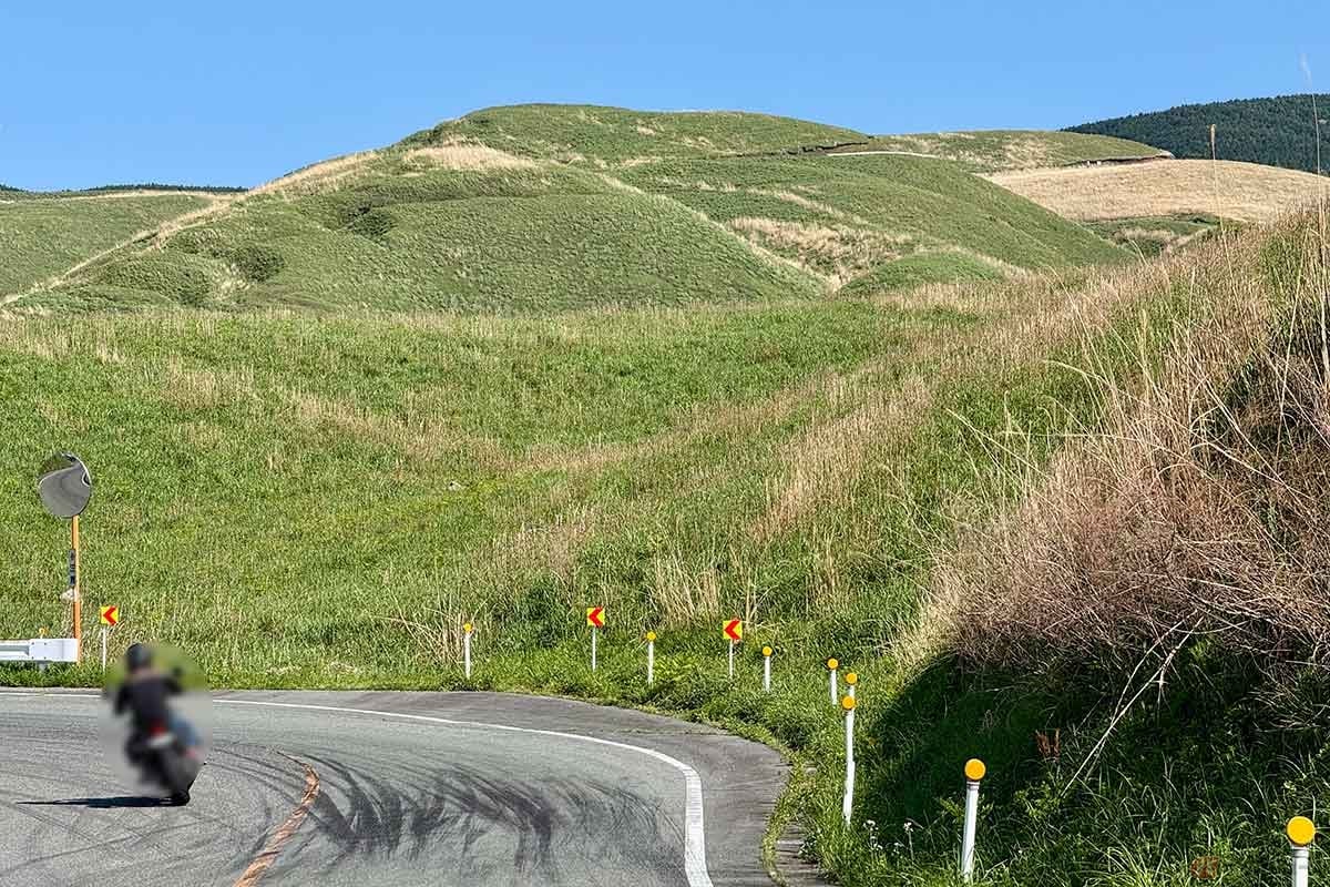 「俵山峠」山頂を目指すヒルクライムルート。阿蘇らしい草原地帯を走る。遠く高くにはこの先に登る道のガードレールが見えています