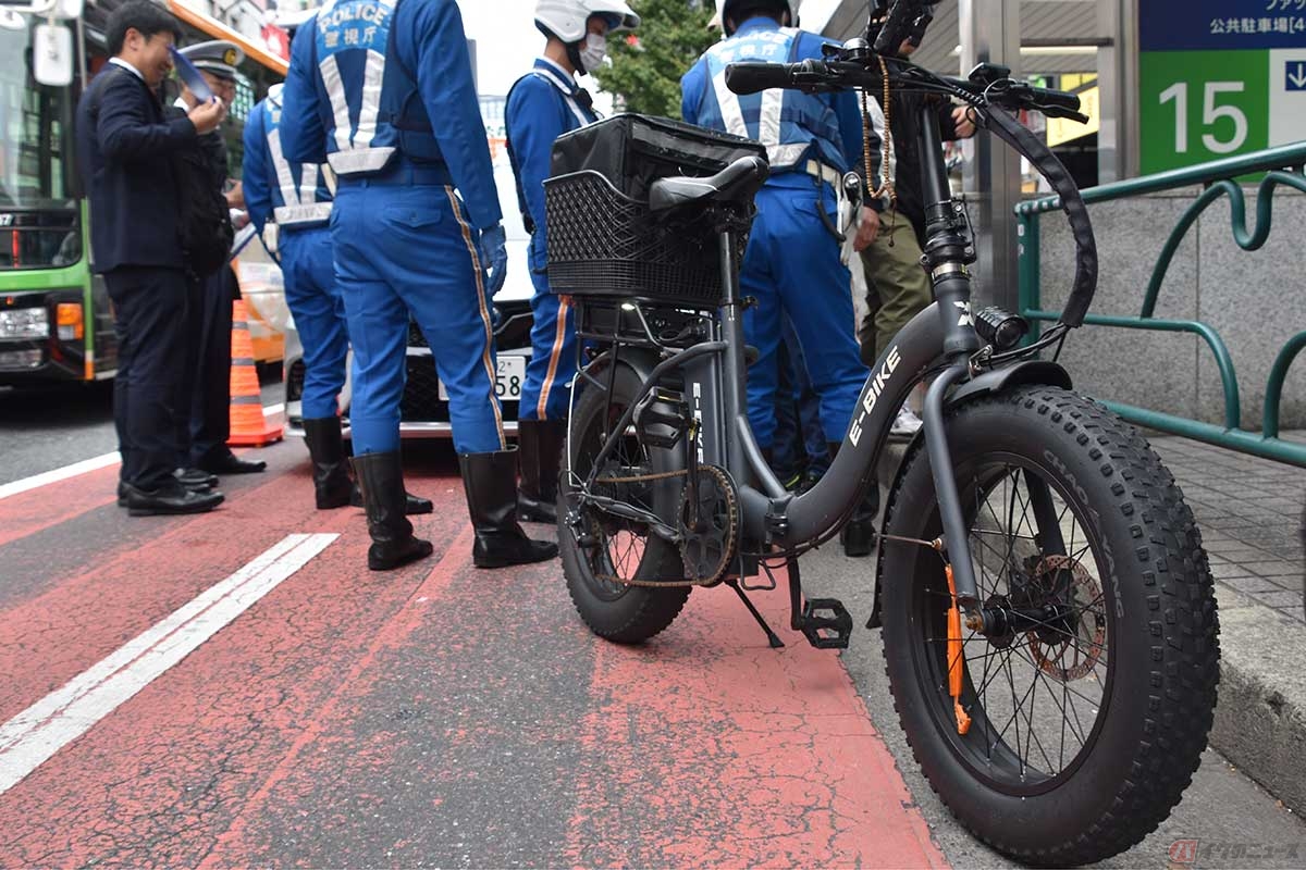 「ペダル付き電動バイク」（＝モペット）の取り締まりをする警察官（2024年11月1日／時事通信フォト）