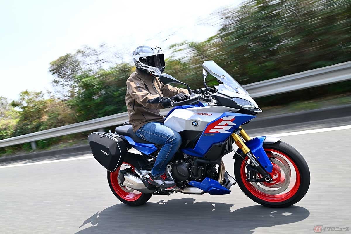 BMW Motorrad「F 900 XR」(2025年型)に試乗する筆者(中村友彦)。カラー:ライト・ホワイト/レーシング・ブルー・メタリック/レーシング・レッド(エンジンスポイラー標準装備) ※撮影車両は純正アクセサリーのソフトケース装着車