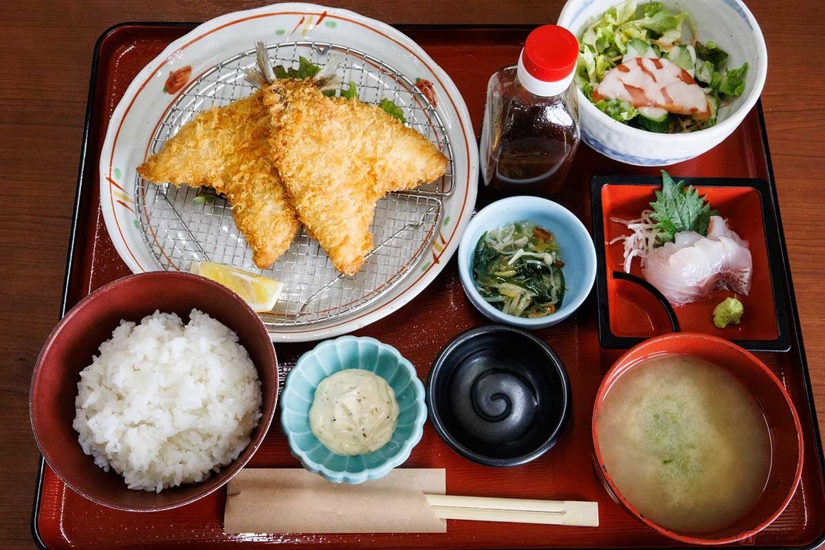 「市場の食堂 金目亭」の「アジフライ定食(刺身1点付)」は、アジフライに刺身やサラダ、小鉢が並ぶボリュームがあって嬉しい定食